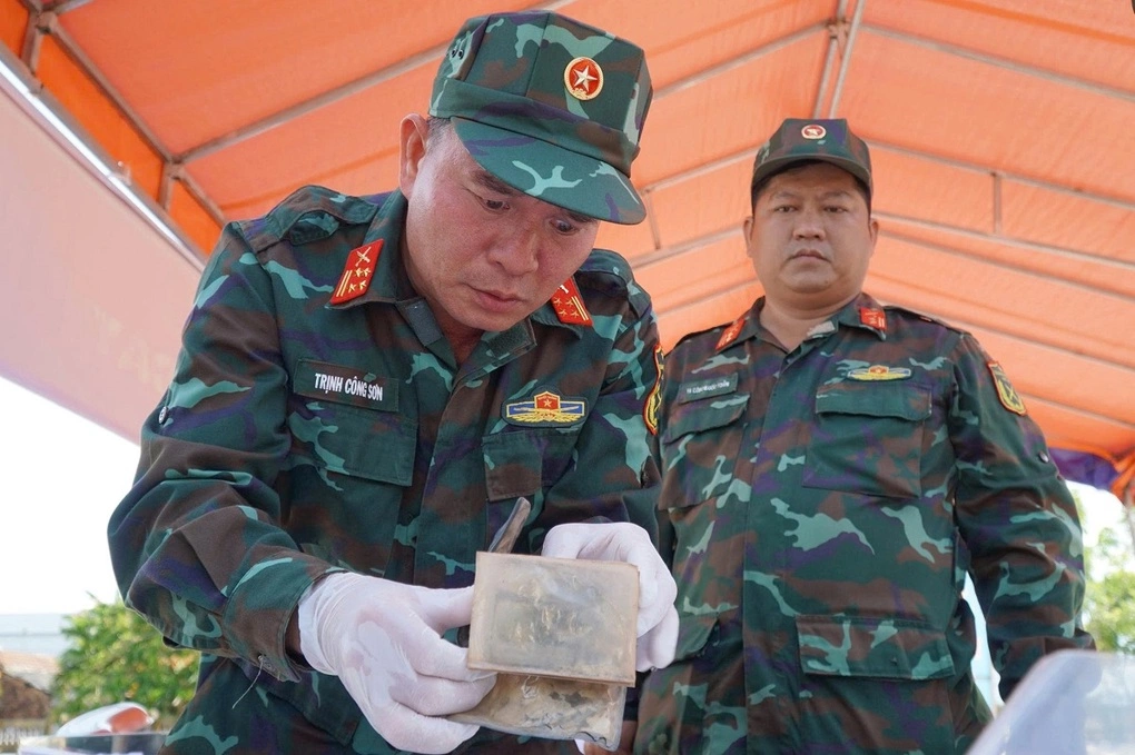 Đại tá Trịnh Công Sơn xem kỹ chiếc ví da có hai ảnh chân dung. Ảnh: Ngọc Linh