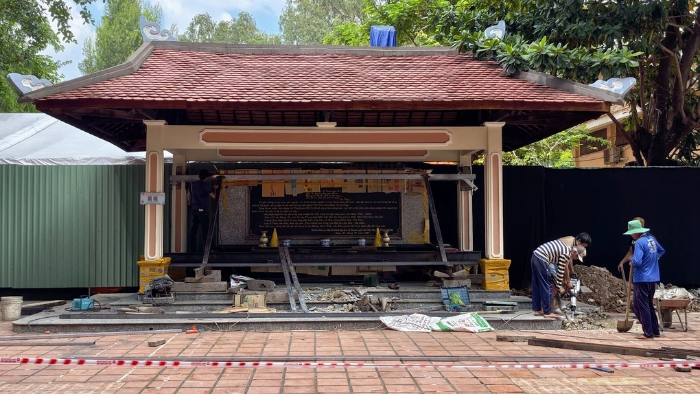 Lực lượng chức năng đào quanh trụ bia tưởng niệm để chuẩn bị di dời, mở rộng hố chôn tập thể đầu tiên ở công viên Lê Thị Riêng. Ảnh: Đình Văn