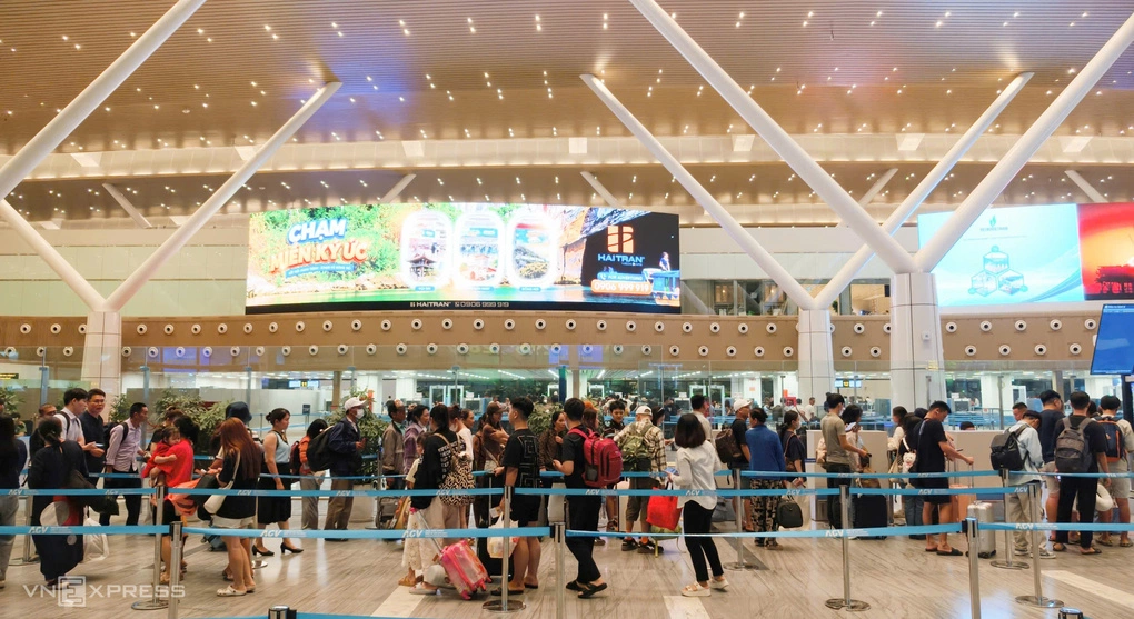 Hành khách xếp hàng chờ check in qua cổng an ninh ở nhà ga T3, sự cố UAV khiến nhiều chuyến bay đi bị ảnh hưởng, lùi giờ khởi hành nên lượng người tập trung làm thủ tục dồn về một thời điểm, đêm 11/8. Ảnh: Đình Văn