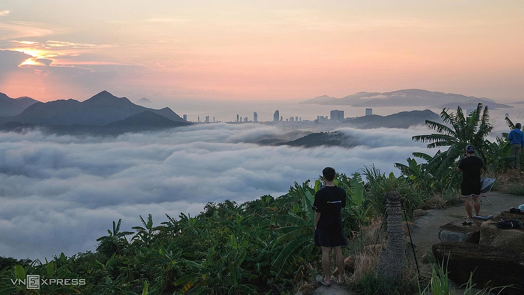 Anh Hoàng Sơn chiêm ngưỡng cảnh mây bao quanh các sườn núi, khu dân cư ở Nha Trang. Ảnh: Bùi Toàn