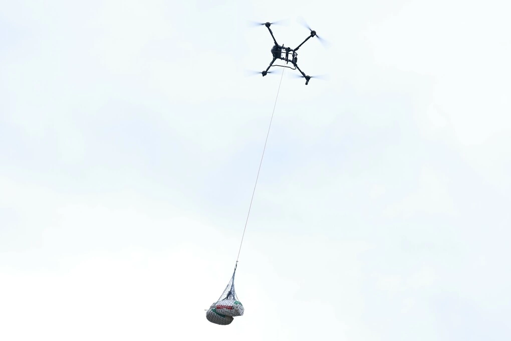 Những bao cà phê sau thu hoạch được vận chuyển từ vùng sản xuất xuống núi bằng UAV. Ảnh: Đàm Minh