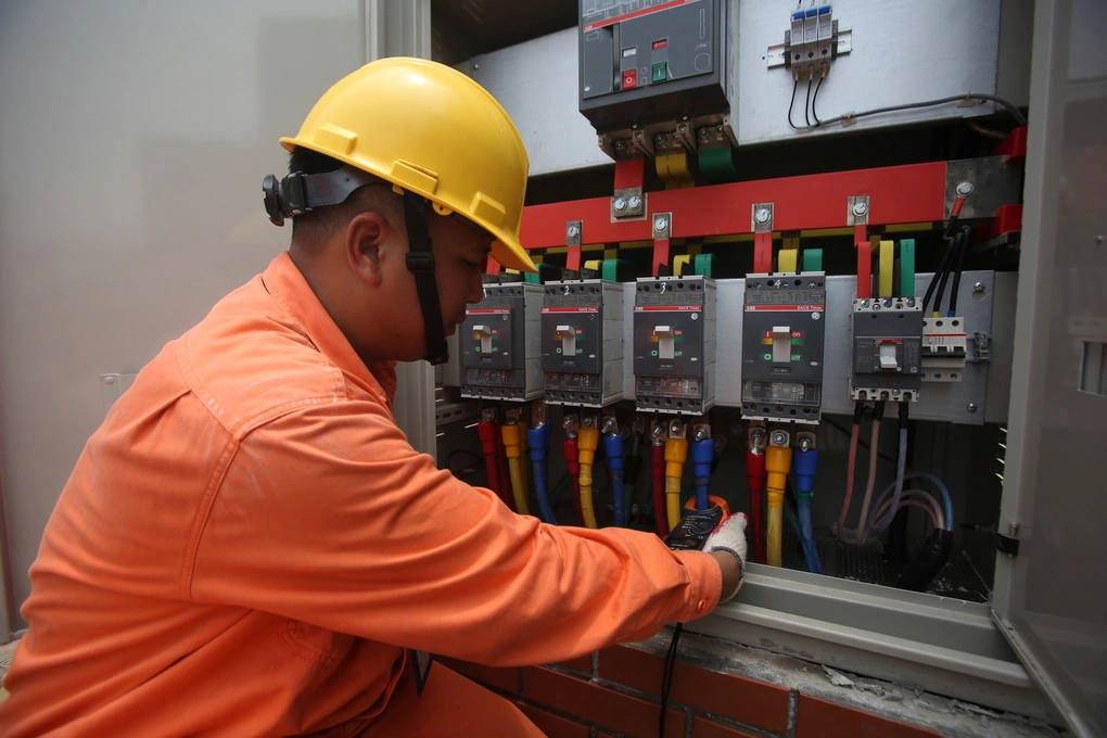 Nhân viên điện lực kiểm tra thiết bị. Ảnh: Ngọc Thành